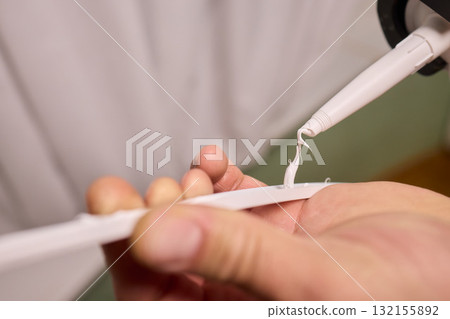 Hand Applying Adhesive with a Caulking Gun for Various Home Interior and Exterior Projects Hand Applying Adhesive with a Caulking Gun for Various Home Interior and Exterior Projects 132155892