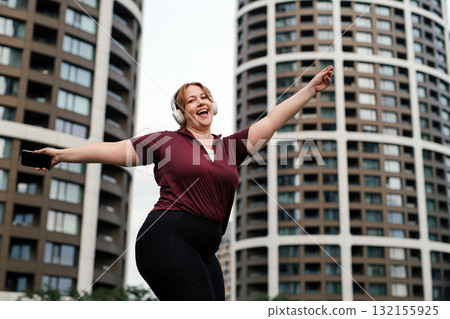 Body positive woman listening music during sport training. Body positive woman listening music during sport training. 132155925