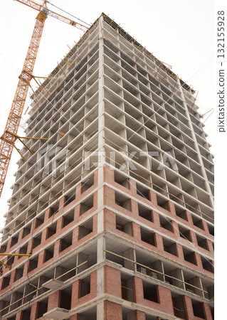 A bustling Construction Site showcasing Cranes, Building Framework, and full activity all around 132155928