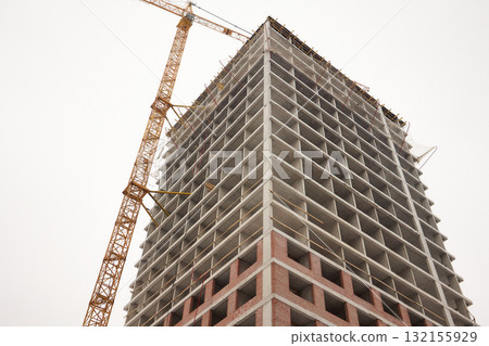 A bustling Construction Site showcasing Cranes, Building Framework, and full activity all around 132155929