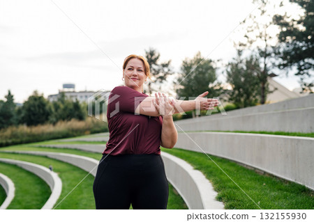Body positive woman warming up before training. 132155930