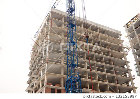 A bustling Construction Site showcasing Cranes, Building Framework, and full activity all around A bustling Construction Site showcasing Cranes, Building Framework, and full activity all around 132155987