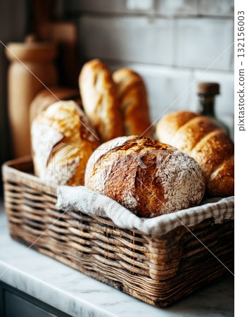 Fresh artisan sourdough bread loaves in wicker basket 132156003