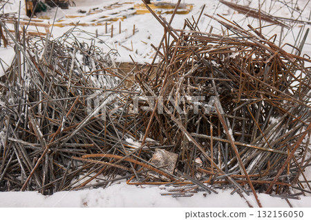 A construction site with piles of organized reinforced steel bars being prepared for use A construction site with piles of organized reinforced steel bars being prepared for use 132156050