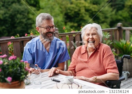 Nurse helping elderly woman measure blood sugar with glucometer. 132156124