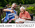 Caregiver pouring fresh wather to elderly woman. 132156127