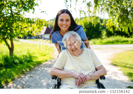 Home nurse taking care of elderly woman in wheelchair. Home nurse taking care of elderly woman in wheelchair. 132156142