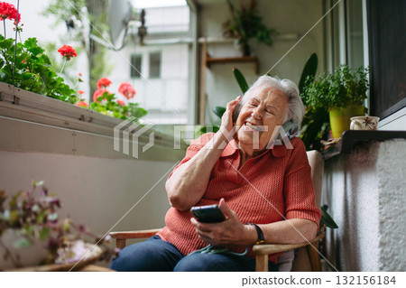 Portrait of senior woman listening podcats from smartphone. 132156184