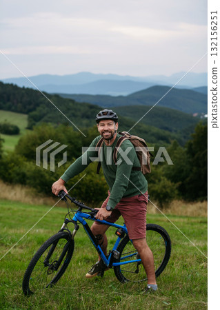 miling mature man with bicycle enjoying countryside ride at sunset. miling mature man with bicycle enjoying countryside ride at sunset. 132156251