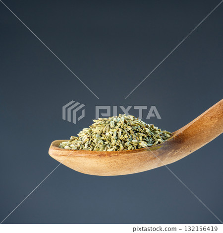 Heap of fennel spice seeds on rustic wooden utensil, great for healthy cooking and ingredient themes 132156419