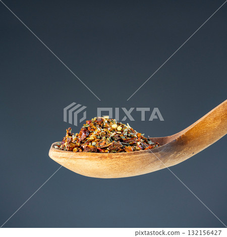 Aromatic spice mixture piled on rustic wooden utensil, great for gourmet cooking and flavor enhancement themes 132156427