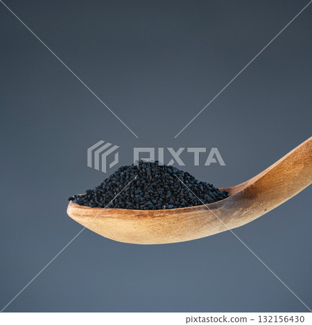 Dark nigella seeds in natural wood spoon, ideal for spice, seasoning and exotic recipe preparation concepts Dark nigella seeds in natural wood spoon, ideal for spice, seasoning and exotic recipe preparation concepts 132156430