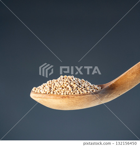 Dried whole pepper seeds displayed in rustic wood ladle, ideal for cooking ingredients and organic food photography 132156450
