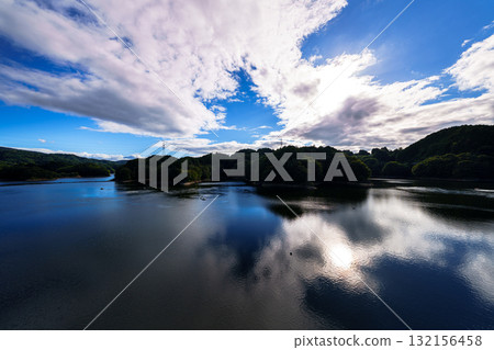 White clouds floating in the blue sky and the lake surface reflecting the beautiful sky at Nara Nunome Dam① 132156458