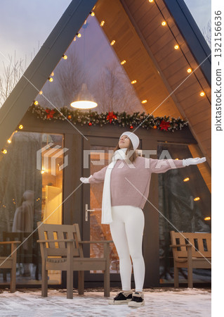 Winter Sunrise Joy: Woman Welcomes New Beginnings With Arms Outstretched at Her Forest Cabin on the First Morning of the Year Winter Sunrise Joy: Woman Welcomes New Beginnings With Arms Outstretched at Her Forest Cabin on the First Morning of the Year 132156636