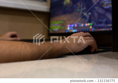 Close up of person hand on gaming mouse, interacting with video game displayed on computer screen. The image focuses on gaming experience with vibrant colors and detailed in game elements 132156775