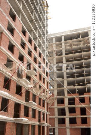 A bustling Construction Site showcasing Cranes, Building Framework, and full activity all around 132156930