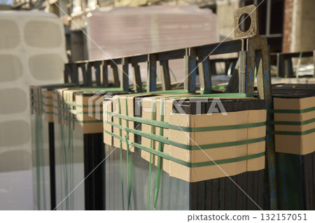 The installation of construction glass panels is taking place at the building site 132157051