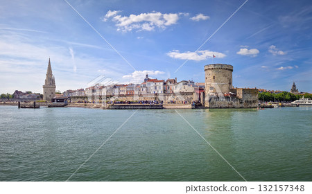 The entrance to the Vieux Port of La Rochelle, France. Panoramic view of all the medieval landmarks guarding the marina, the chain and the lantern towers The entrance to the Vieux Port of La Rochelle, France. Panoramic view of all the medieval landmarks guarding the marina, the chain and the lantern towers 132157348