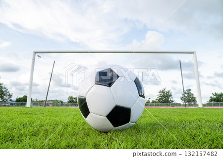 Footballs on the field and goal nets in a large stadium 132157482