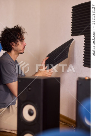 Setting up audio equipment with soundproofing panels in a modern studio environment Setting up audio equipment with soundproofing panels in a modern studio environment 132158127
