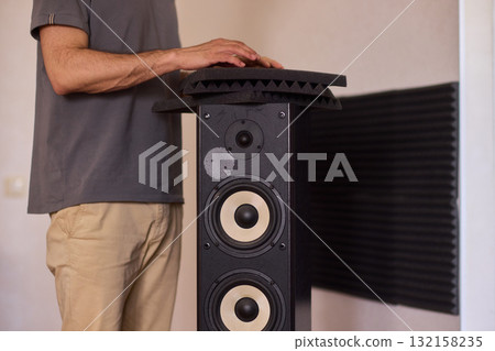 Setting up audio equipment with soundproofing panels in a modern studio environment Setting up audio equipment with soundproofing panels in a modern studio environment 132158235