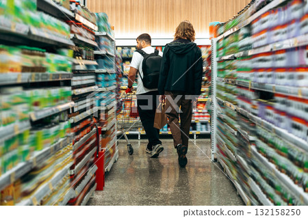 Grocery shopping trip with friends in a well-stocked supermarket aisle Grocery shopping trip with friends in a well-stocked supermarket aisle 132158250