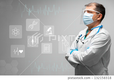 A healthcare worker stands thoughtfully, wearing a mask and glasses, amidst digital health symbols 132158318