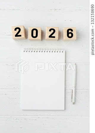 Wooden cubes with numbers for the New Year 2026 with a notebook and pen 132158690