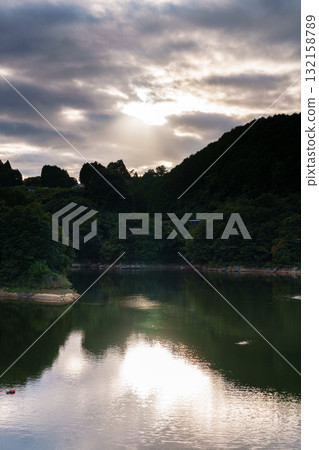 Mid-Autumn Festival at Nara Nunome Dam: The lake surface is brightly illuminated by the setting sun peeking through the clouds① 132158789