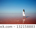 beautiful girl in white dress standing in pink water 132158883