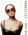 Beautiful woman in color sunglasses and leather bra 132158884