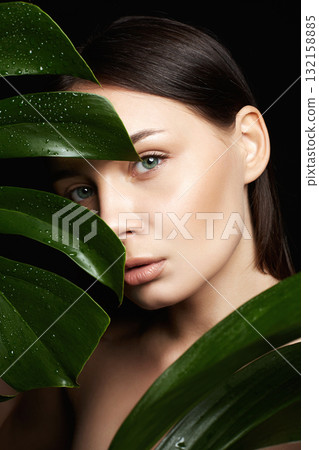 beautiful girl in palm leaves. Beautiful woman with Make-up beautiful girl in palm leaves. Beautiful woman with Make-up 132158885