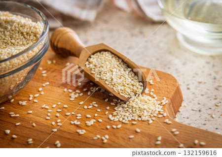 Roasted sesame seeds in scoop on cutting board. 132159616