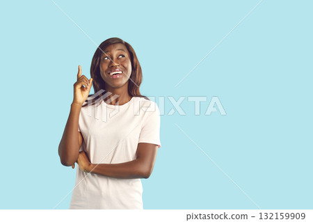 Smiling young woman in casual clothes pointing up with her finger isolated on blue background Smiling young woman in casual clothes pointing up with her finger isolated on blue background 132159909