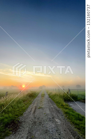 A Misty and Beautiful Sunrise Over a Serene and Peaceful Country Road in the Countryside A Misty and Beautiful Sunrise Over a Serene and Peaceful Country Road in the Countryside 132160737