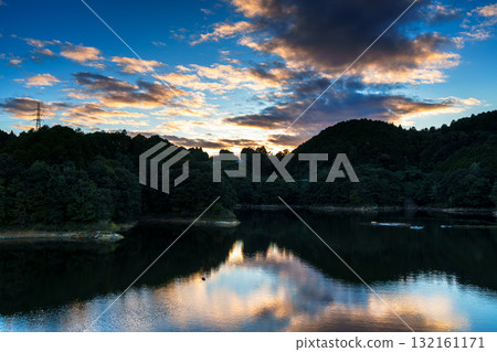 奈良布目水壩布目湖上空的中秋日落空。烏雲籠罩在金色的光芒中，天空倒映在布目湖上。 132161171