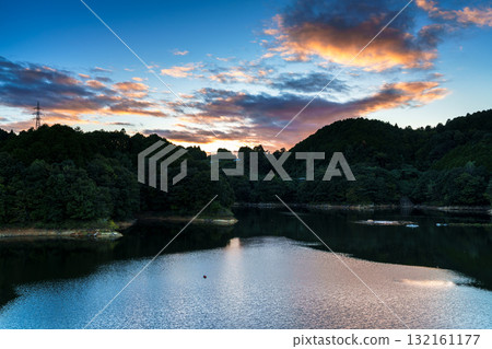 奈良布目水壩布目湖上空的中秋日落空。烏雲籠罩在金色的光芒中，天空倒映在布目湖上。 132161177