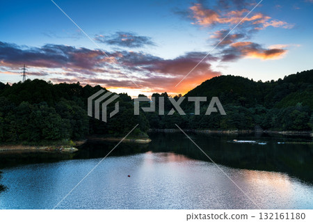 奈良布目水壩布目湖上空的中秋日落空。烏雲籠罩在金色的光芒中，天空倒映在布目湖上。 132161180
