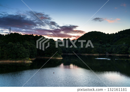 奈良布目湖水壩的秋日夕陽。山腰上飄浮著鮮紅的雲彩，天空呈現漸層的色澤。 132161181