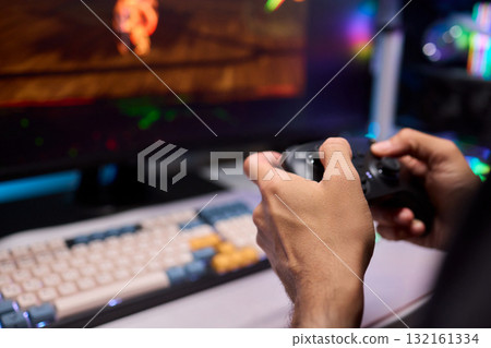 Enjoying an exciting gaming session with a controller and large screen for immersive gameplay 132161334