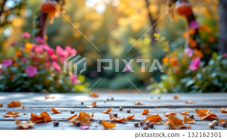 An outdoor setting during autumn, with fallen leaves scattered around and resting on the wooden surface of a patio 132162301