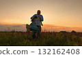 Happy spins and hugs, Sunset in a wild field, Dad sharing fun times, Laughter at golden hour, Carefree in nature together, Father-daughter joy in bloom, Open fields and happiness, Evening moments in 132162408