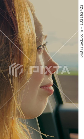 Blonde girl, car journey, smiling through window, sunlight reflections, enjoying ride, adventure mood, positive emotions, natural beauty, travel excitement, bright day, Woman looking out of car, smile 132162422