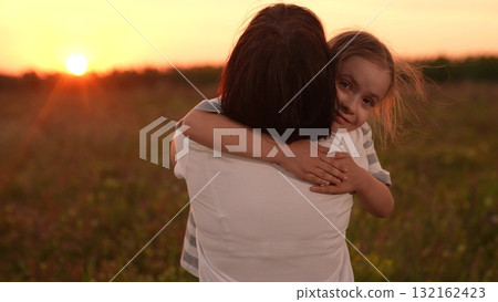 A little girl runs to her mother at sunset, Family reunion in the field, Warm sunset embrace, Joyful child in nature, Mother and daughter happy moment, Open arms and big smiles, Summertime meadow 132162423