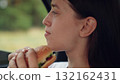 woman girl eating burger car, happy person, Hungry woman portrait, Satisfying fast food, Natural light photo, Quick snack on road, Burger closeup, Calm and relaxed, Afternoon break, Nature in 132162431