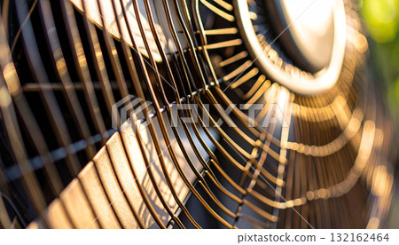 Macro detail of a vintage fan grill with a warm, sunny green bokeh background, with copy space. 132162464