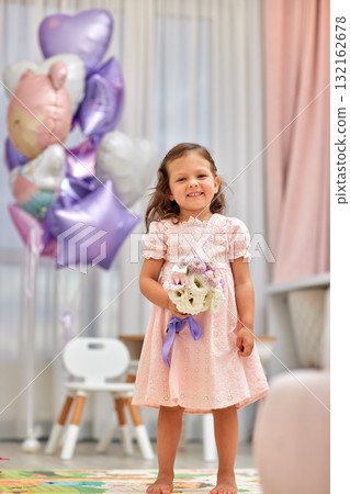 Cute little child girl in pink dress with flowers and pink purple balloons. Birthday concept. Cute little child girl in pink dress with flowers and pink purple balloons. Birthday concept. 132162678