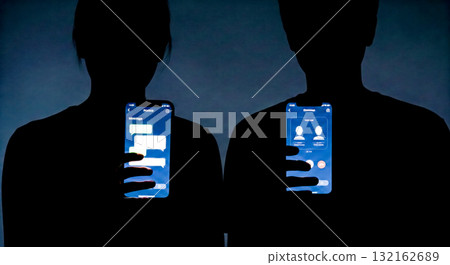 Social Media Privacy Concept with two anonymous silhouettes holding glowing smartphones, showing online chat and user profiles in dark abstract background 132162689