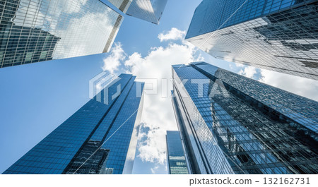 Modern skyscrapers in financial district, low angle view of glass office buildings against blue sky with clouds, business and success concept 132162731